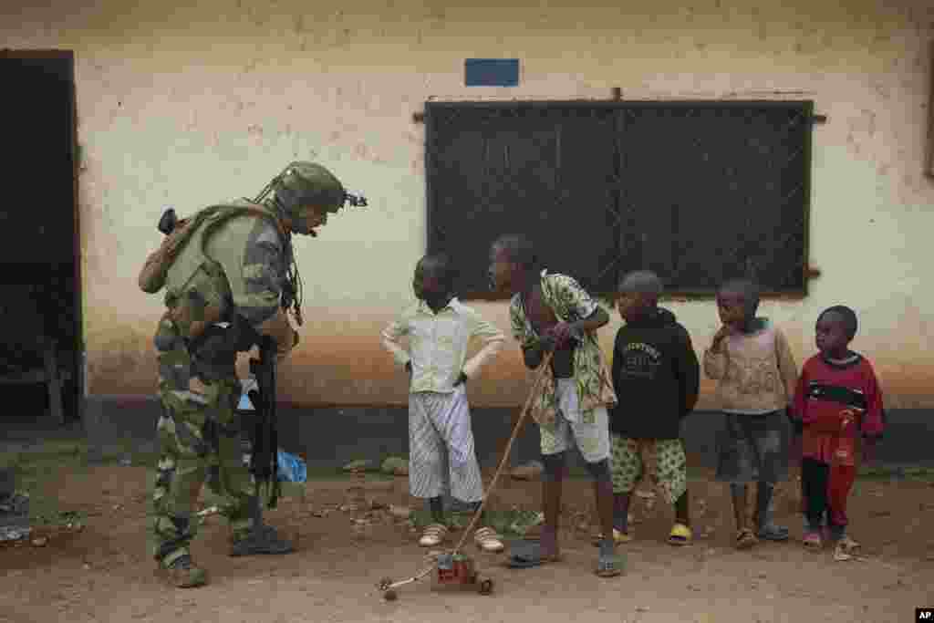 A French soldier talks to curious children as he mans a roadblock in the Miskine neighborhood of Bangui, Central African Republic. 