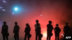 FILE - Police hold a perimeter near the White House as demonstrators gather to protest the killing of George Floyd in the morning hours on May 31, 2020 in Washington, D.C.
