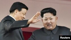 지난 13일 북한 평양에서 열린 노동당 창건 70주년 기념식에서 김정은 국방위원회 제1위원장(오른쪽)이 중국 대표단을 이끌고 방북한 류윈산 공산당 정치국 상무위원과 함께 열병식을 참관하고 있다.