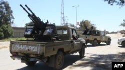Gun-mounted vehicles belonging to fighters loyal to the internationally recognized Libyan Government of National Accord (GNA) are pictured near a military compound in a suburb of the capital Tripoli on April 9, 2019.