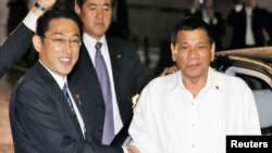 25일 일본을 방문한 로드리고 두테르테 필리핀 대통령(오른쪽)이 기시다 후미오 일본 외무상이 주최한 만찬장에 들어서며 악수하고 있다.