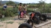 Kea Teav and her family stand in front of a two-wheeled tractor that was burnt down by a member of the Wildlife Alliance team in Krakor district, Pursat province, Cambodia, August 5, 2020. (Sun Narin/VOA Khmer)