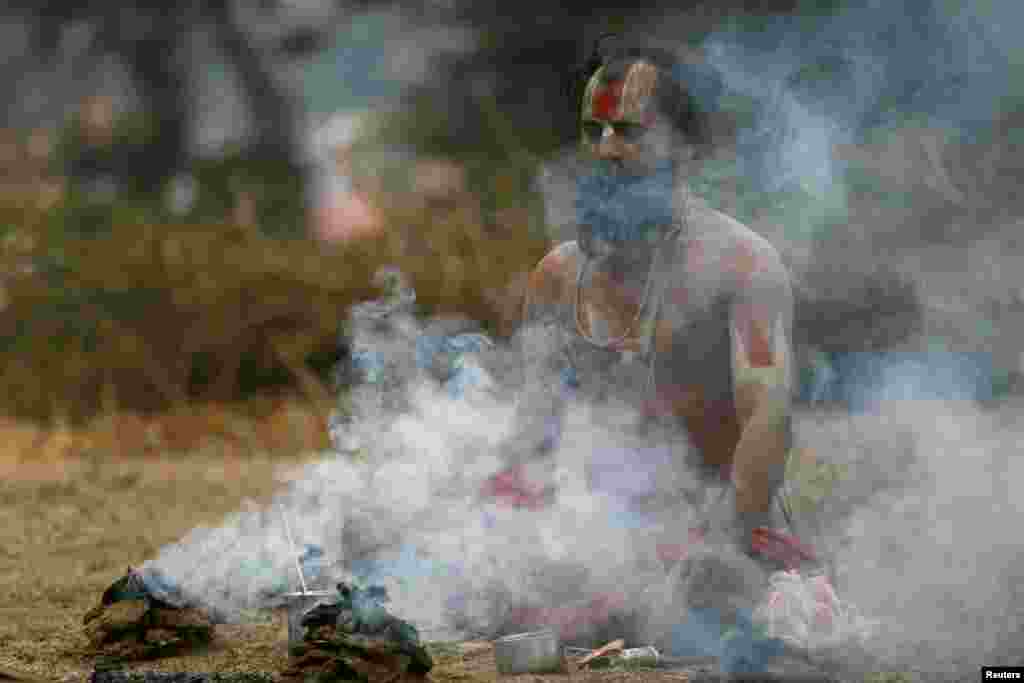 ផ្សែងហុយ​ចេញ​មក​ខណ​ដែល​បុរស​​កាន់សាសនា​ហិណ្ឌូ​ម្នាក់​សម្តែង​ពិធី​សាសនា​នៅ​ប្រាសាទ Pashupatinath អំឡុង​បុណ្យShivaratri នៅ​ក្នុង​ទីក្រុង Kathmandu ប្រទេស​នេប៉ាល់។