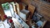  Workers from Second Chance remove all usable material from a log cabin which is scheduled to be torn down. (J. Taboh/VOA) 