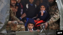 Tentara Pakistan mengangkut anak-anak sekolah yang diselamatkan dari lokasi serangan Taliban di sebuah sekolah di Peshawar (16/12). (AFP/A. Majeed)