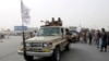 Taliban fighters patrol on the road during a celebration marking the second anniversary of the withdrawal of U.S.-led troops from Afghanistan, in Kandahar, south of Kabul, Afghanistan, Aug. 15, 2023.