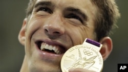 菲尔普斯7月31日在伦敦奥运会上手持他在4x200米自由泳接力中赢得的金牌