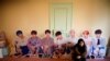 FILE - A fan of K-pop idol boy band BTS poses for photographs with cut-out of BTS at a pop-up store selling BTS goods in Seoul, South Korea, Dec. 24, 2019. 