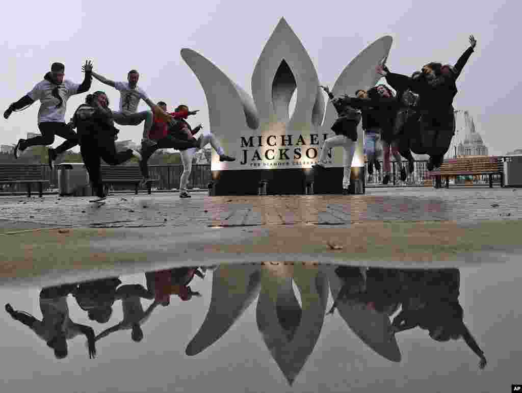 Fans of the former King of Pop Michael Jackson pose for photographers to celebrate Jackson&#39;s Diamond Birthday Celebration with the installation of a giant 13-foot jeweled crown at London&#39;s iconic Southbank.