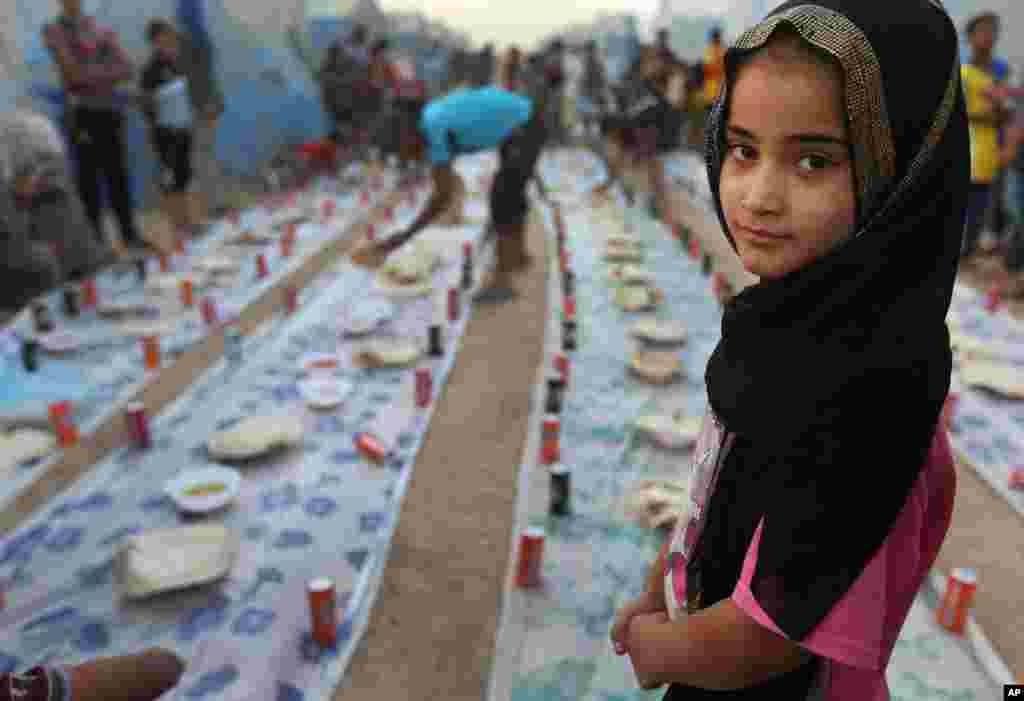 Seorang anak pengungsi Irak menanti saat berbuka puasa bersama di kamp pengungsi di Khazer, di luar Irbil, Irak utara (29/6).&nbsp;(AP/Hussein Malla)