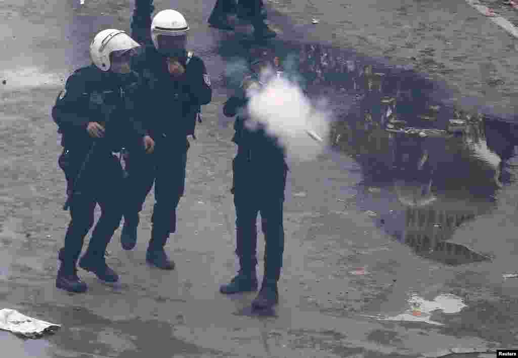 A riot police officer fires tear gas to push back protesters during a May Day demonstration in Istanbul, Turkey.