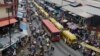 FILE - In this photo taken June 20, 2016, pedestrians shop at a market in Lagos, Nigeria.