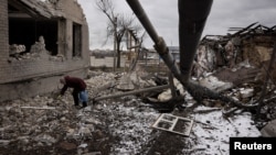 资料照片: 乌克兰人清理被俄罗斯导弹摧毁的房子和院子 (2024年2月19日)