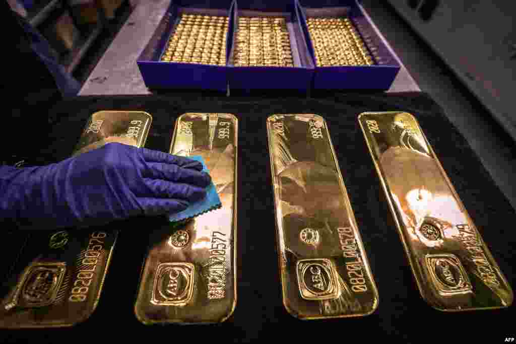 호주 시드니의 &#39;ABC 정련소&#39; 직원이 금괴를 닦고 있다. 최근 국제 금 거래가가 처음으로 온스 당 2천 달러가 넘었다.