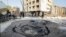 An Egyptian worker checks a hole believed to be caused by a car bombing in the street outside the national security building in the Shubra el-Kheima neighborhood of Cairo, Aug. 20, 2015.
