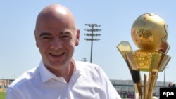 Le président de la FIFA, Gianni Infantino, tient un trophée dedies aux "travailleurs de la Coupe du au Qatar 2016" à Doha, Qatar, 22 avril 2016. epa/ STRINGER