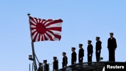 2015年3月25日，日本海军站在即将起航的出云级护卫舰甲板上，即将驶离东京南部的横滨日本联合海上造船厂。