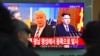 FILE - People watch a television news screen showing pictures of U.S. President Donald Trump and North Korean leader Kim Jong Un at a railway station in Seoul, South Korea, Nov. 29, 2017.
