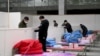 Workers set up infrastructure at the Wuhan International Conference and Exhibition Center to convert it into a makeshift hospital to receive patients infected with the new coronavirus, in Wuhan, Hubei province, China February 4, 2020. Picture taken…