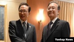 19일 캄보디아 프놈펜에서 열린 한.중 정상회담. 악수하는 이명박 대통령과 중국 원자바오 총리(오른쪽).