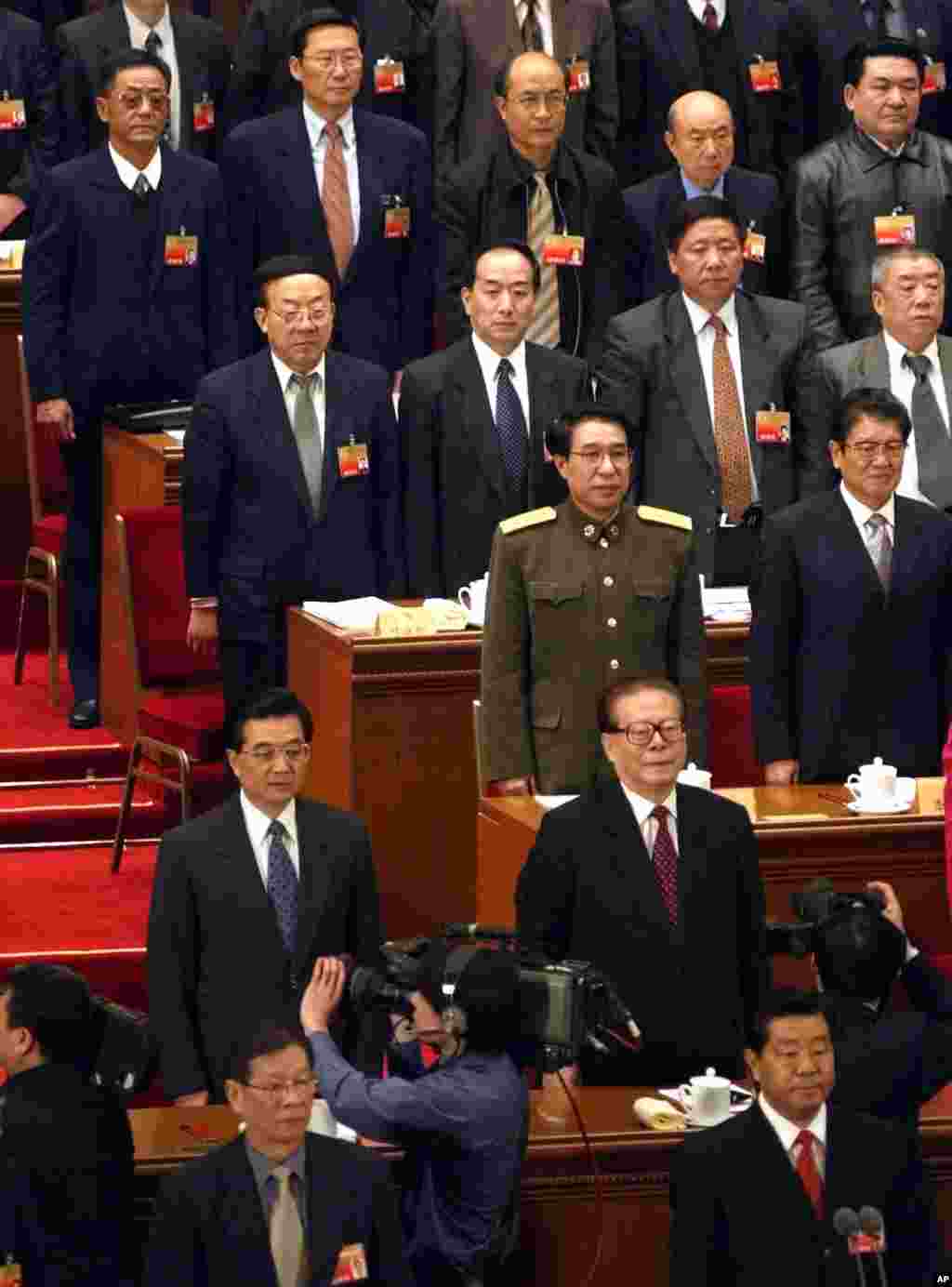 2004年3月12日，在中国政协会议闭幕式上演奏国歌时，中国主席胡锦涛和前主席江泽民起立。江泽民前面是贾庆林，后面是徐才厚。