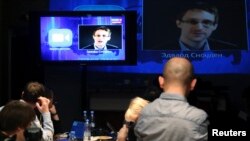 Para wartawan mendengarkan pertanyaan Edward Snowden, di sebuah Media Center di Moskow, saat berlangsungnya acara siaran langsung bersama Presiden Rusia Vladimir Putin, 17 April 2014 (Foto: dok).