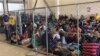FILE - An overcrowded fenced area holding families at a Border Patrol station is seen in a still image from video in McAllen, Texas, June 10, 2019.